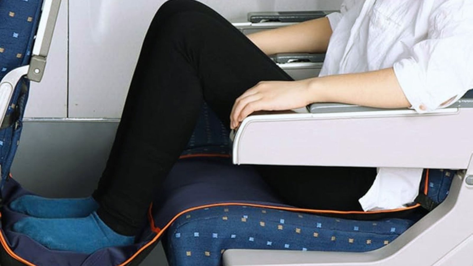  A woman relaxes in an airplane seat with her feet propped up, enjoying her flight.