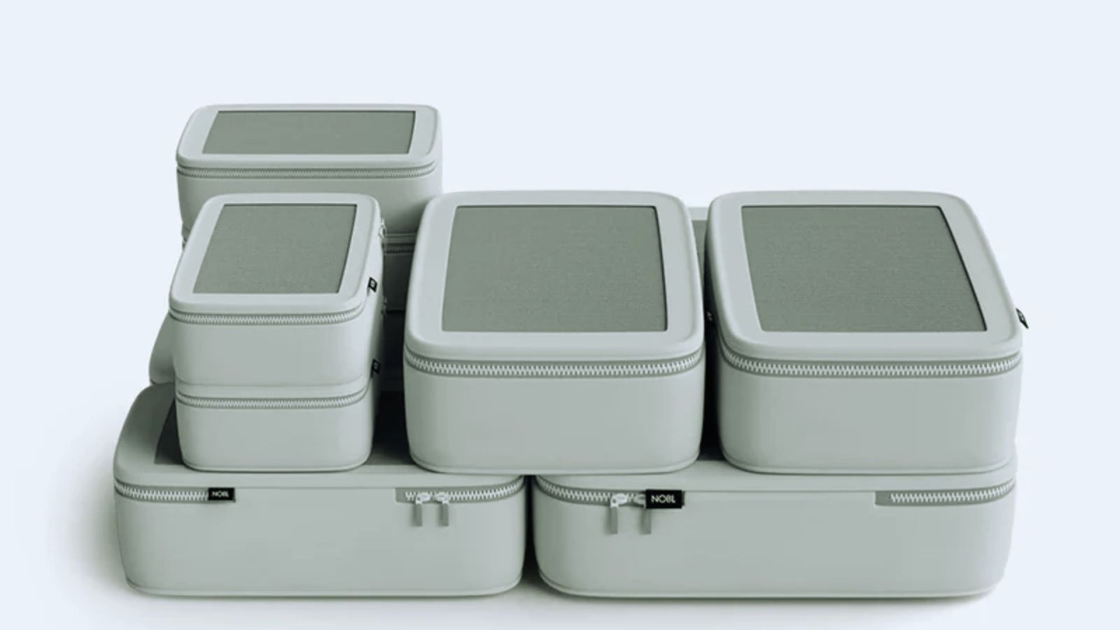 A vertical stack of four gray plastic boxes, with a single lid placed on the top box