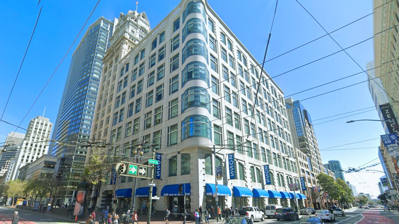  A large building featuring blue awnings along the street, showcasing a vibrant urban environment.
