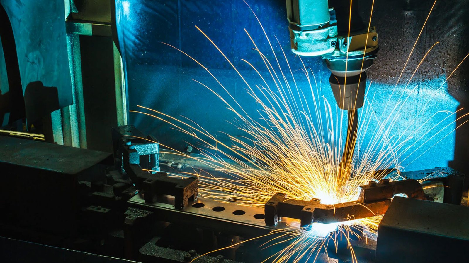  A welding machine in a factory, emitting bright sparks during the welding process.
