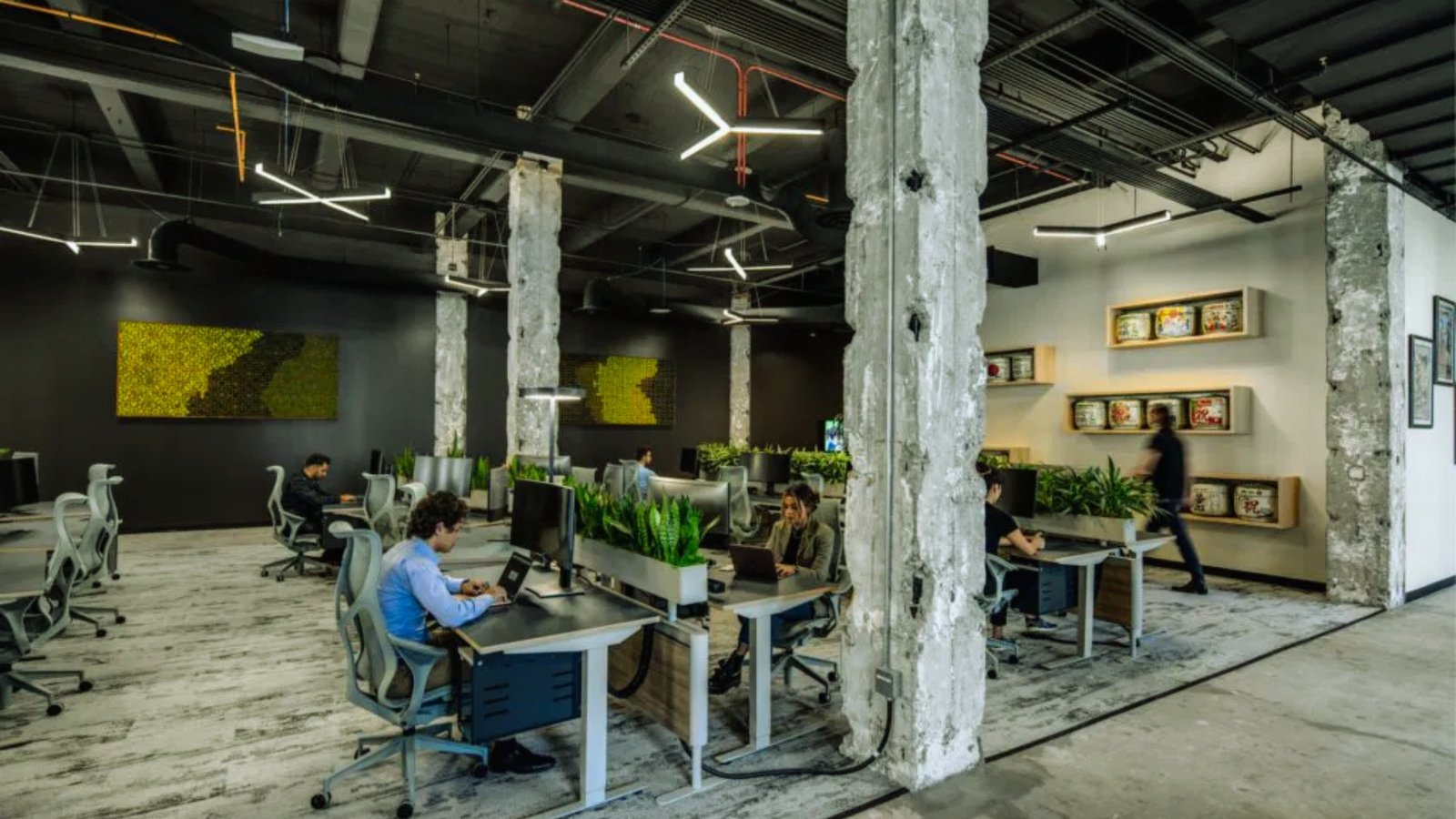  An office scene featuring several people focused on their work at individual desks.
