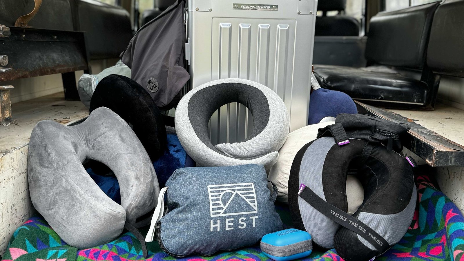 A suitcase containing a pillow, a blanket, and another pillow, arranged neatly for travel comfort.