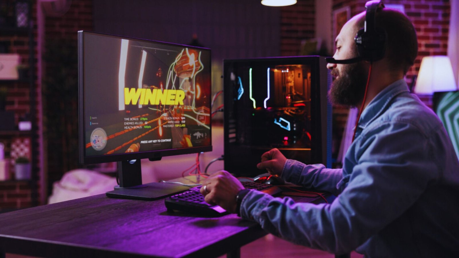 A man focused on playing video games on his computer, with a gaming headset and colorful LED lights in the background.
