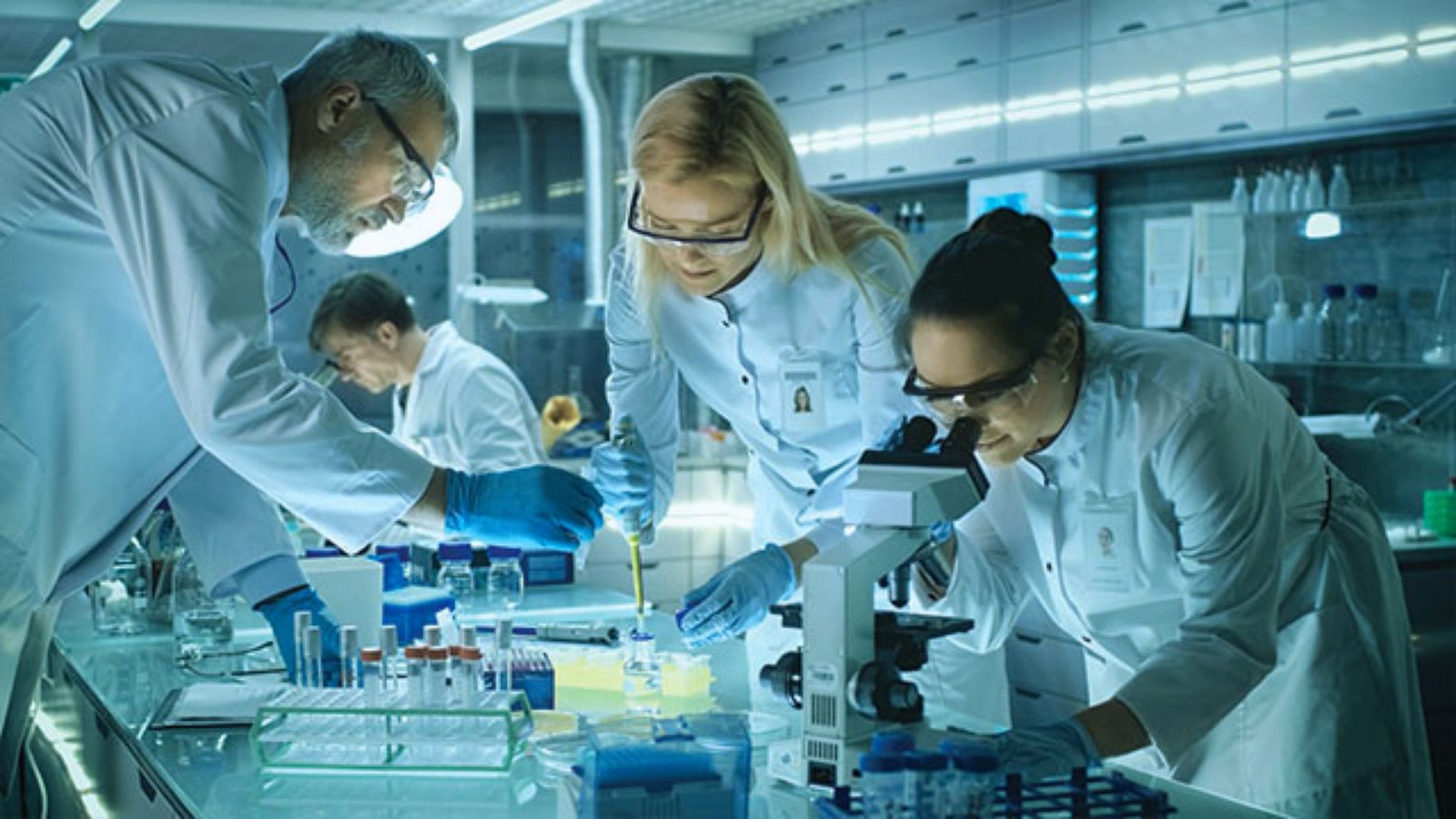 A group of scientists collaborating in a laboratory, surrounded by equipment and research materials.
