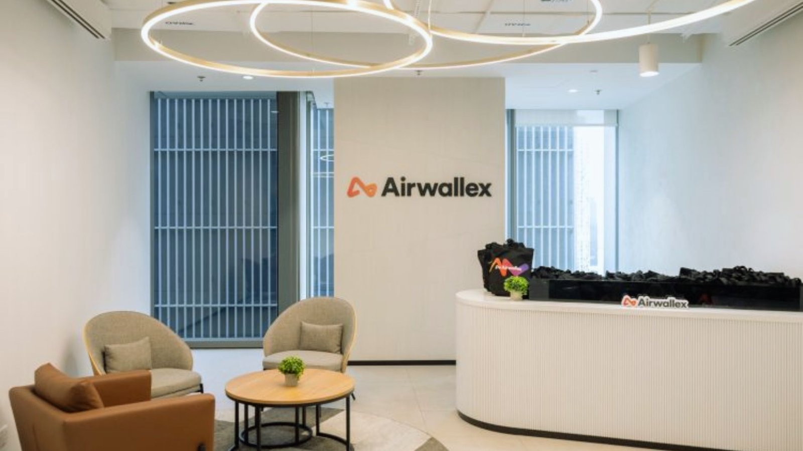 The lobby of an office building featuring a large circular light fixture illuminating the space.