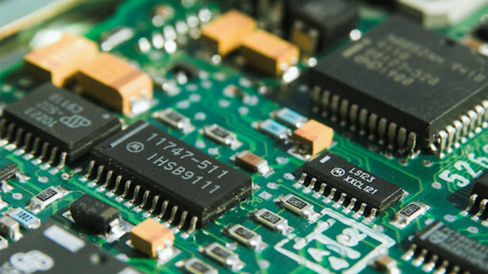  Electronic components arranged on a green circuit board, showcasing various chips and connectors.