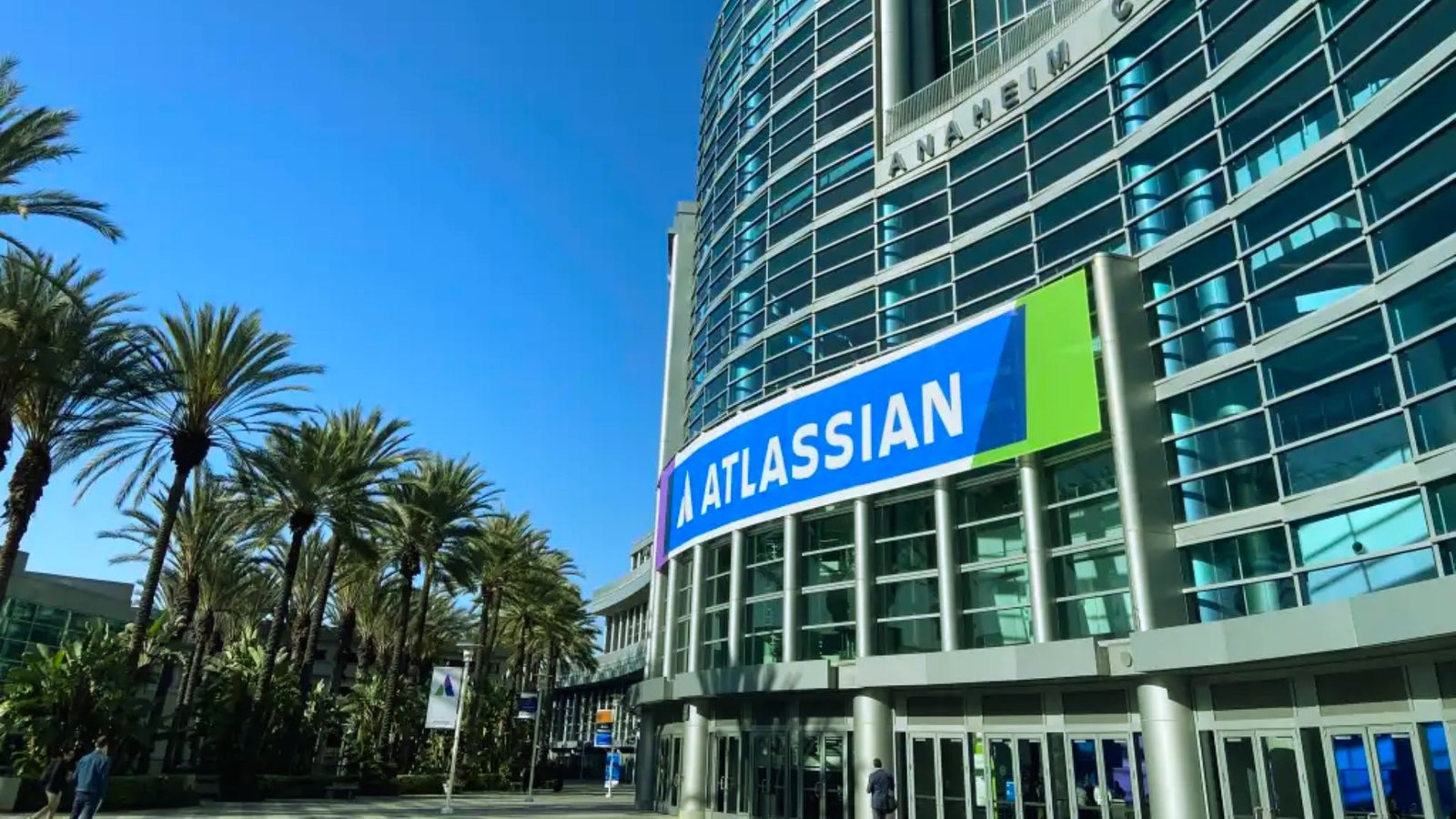 A large California convention center with palm trees in front, showcasing a sunny, vibrant atmosphere.