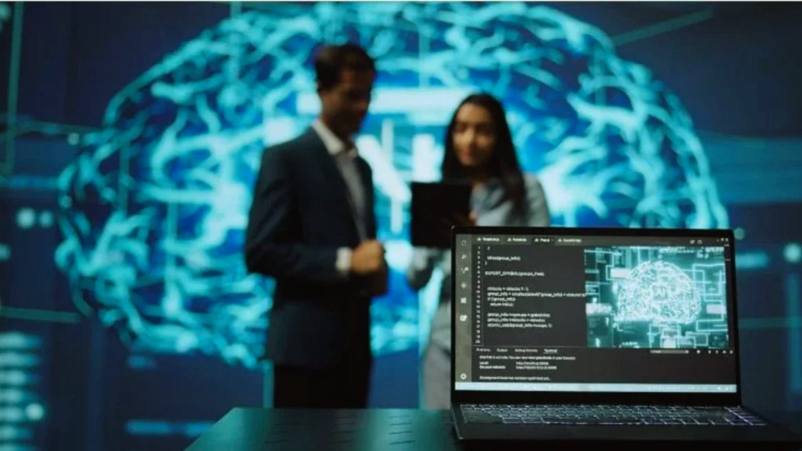  Two individuals stand by a laptop displaying a brain image, engaged in discussion or analysis.