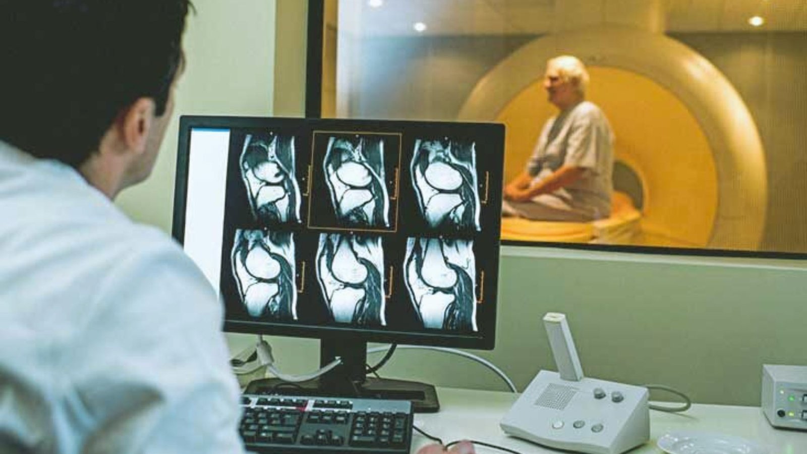  A man analyzes an MRI image displayed on a computer screen while seated at a desk.