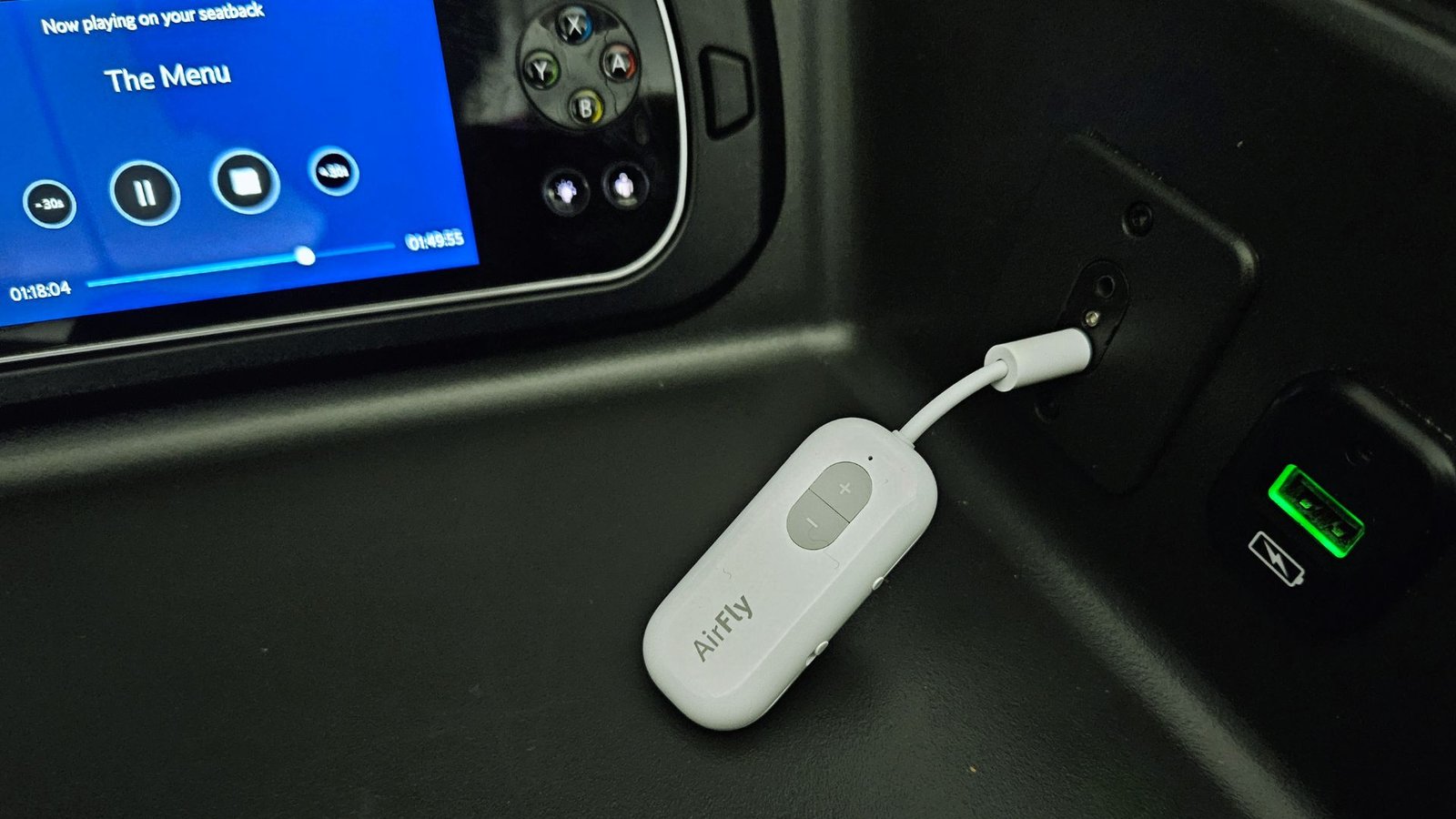  A white device is connected to a car's dashboard, indicating a charging or connectivity function.