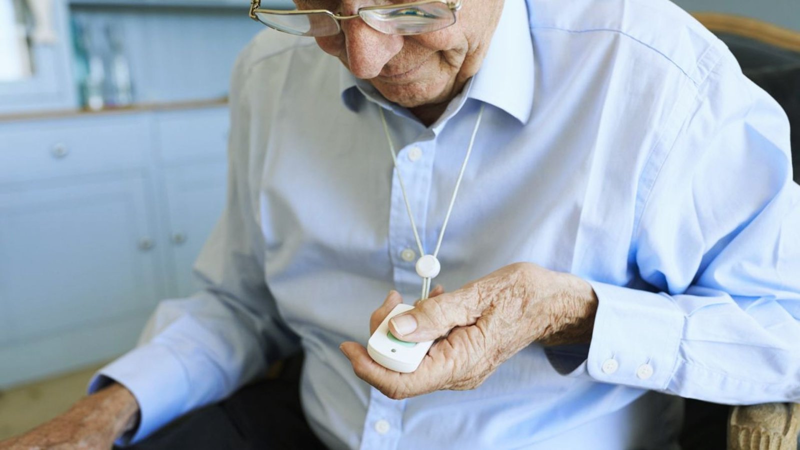  An older man uses a remote control to operate a television in a cozy living room setting.
