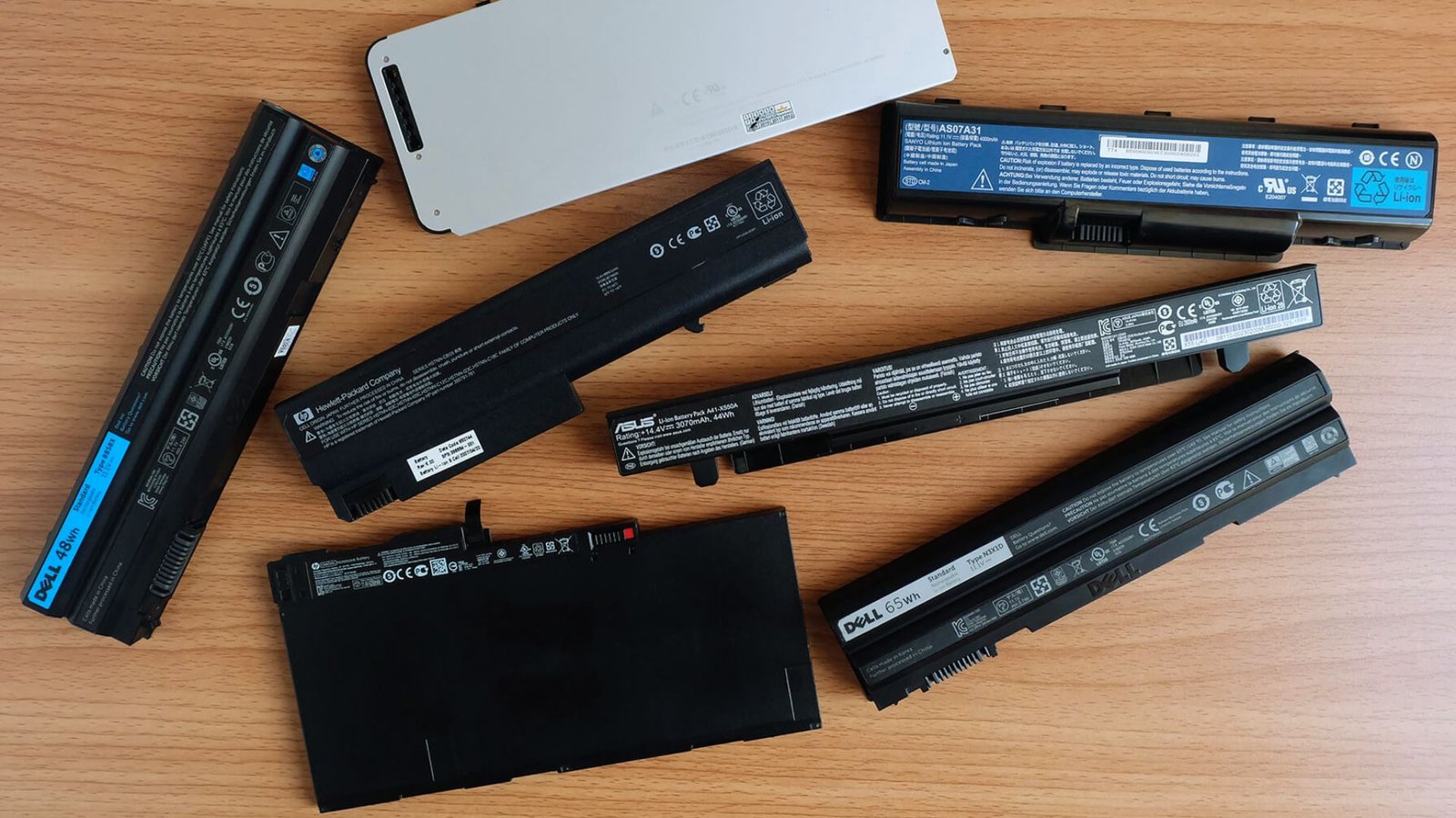  Laptop and tablet batteries displayed together, showcasing various sizes and types for portable devices.