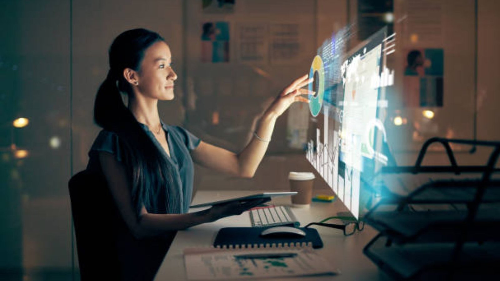 A woman interacting with a computer, viewing a colorful digital image on the screen.