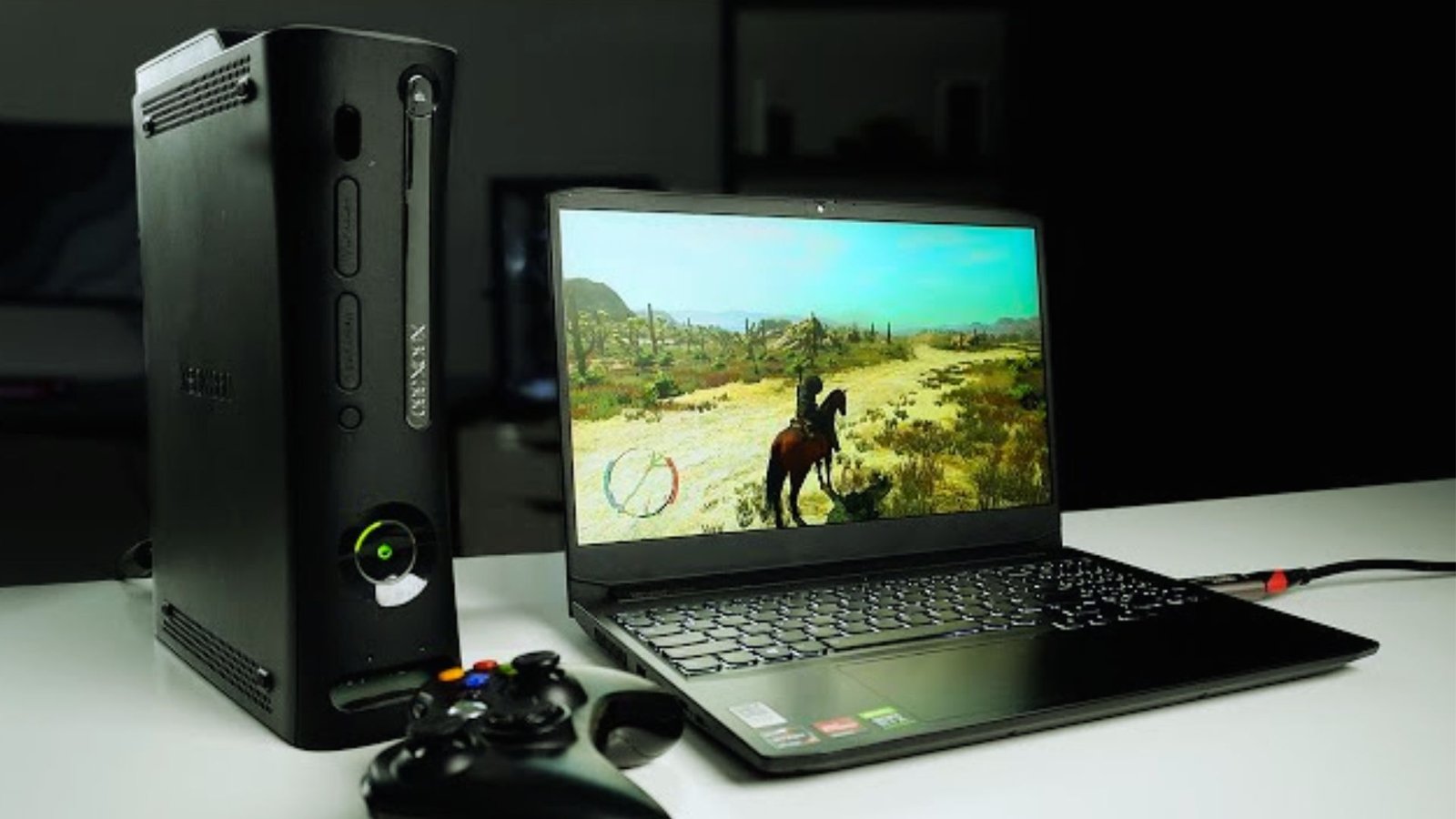  A laptop computer with a game controller placed beside it on a flat surface, suggesting a gaming setup.