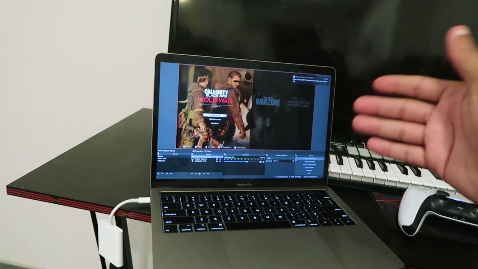  A person holds a laptop computer screen, displaying content towards the viewer.