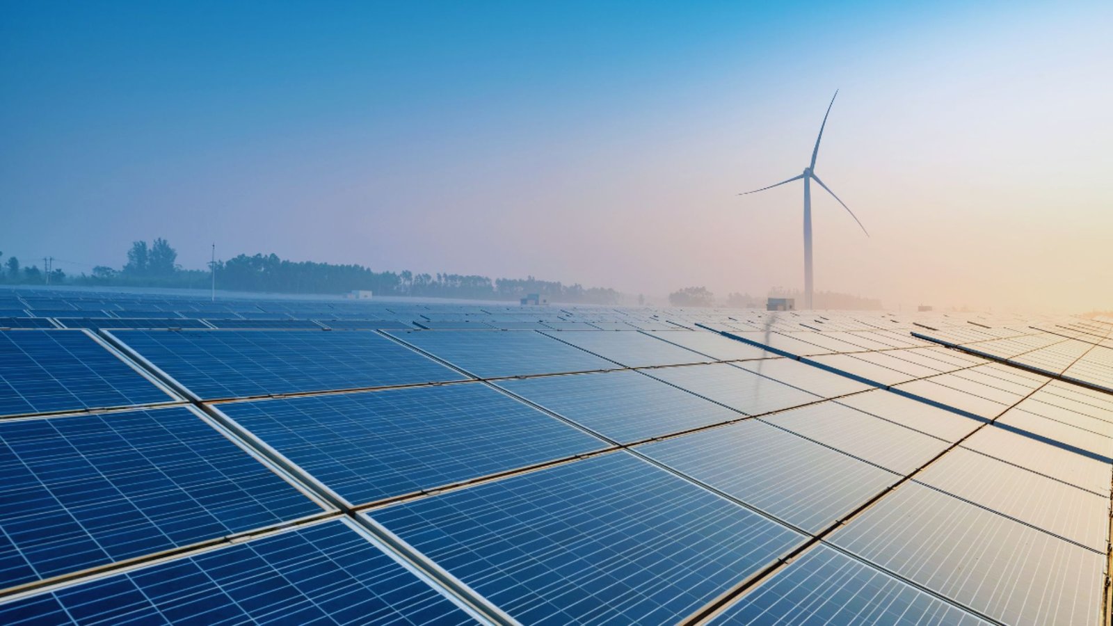 Solar panels and wind turbines bathed in morning light, showcasing renewable energy sources in a clear sky.