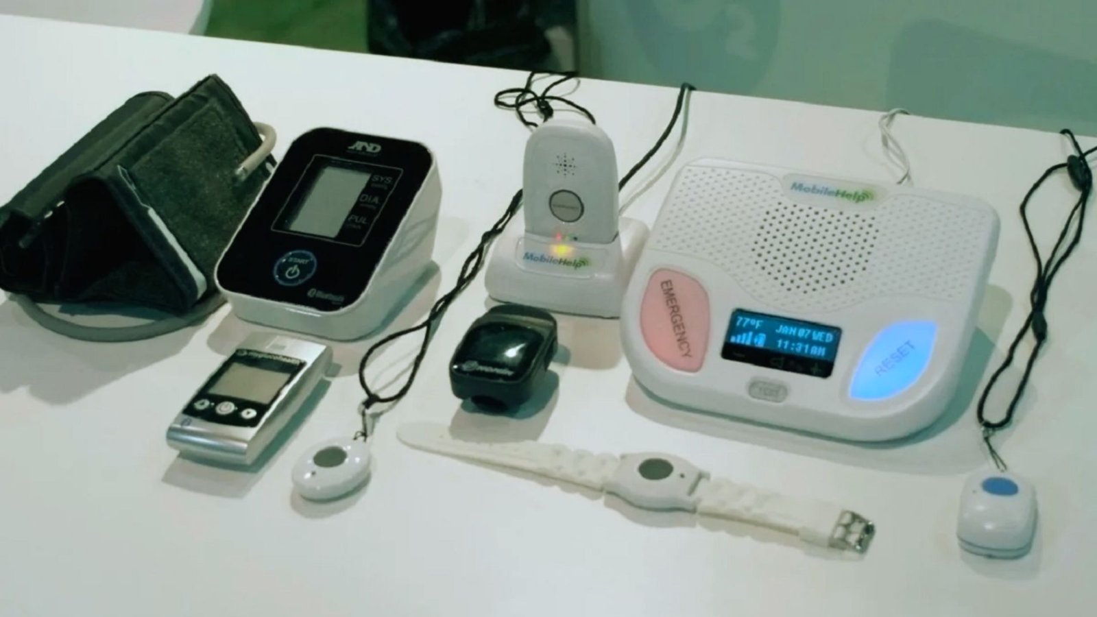 A table displaying a smartphone, smartwatch, and heart monitor, showcasing various electronic health devices.