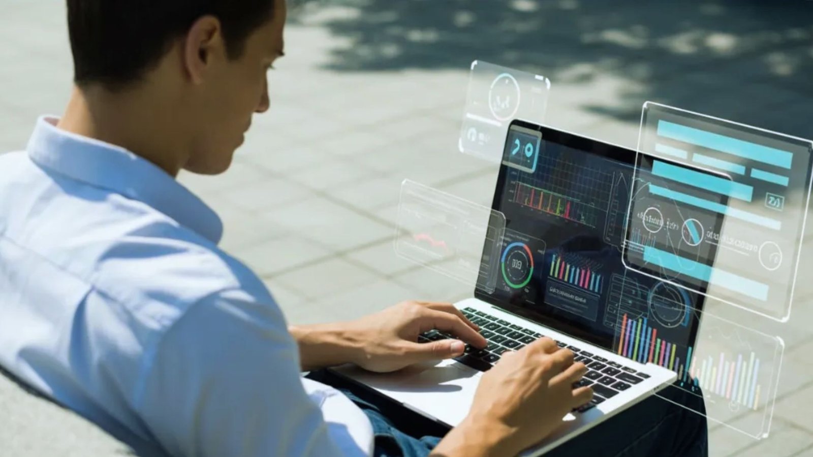  A man sits on a bench using a laptop, with a screen displaying various icons beside him.