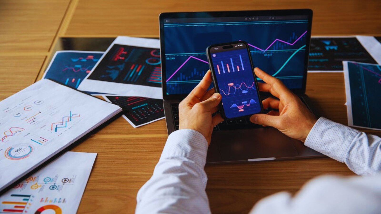 Businessman analyzing data on graphs and charts displayed on his smartphone.