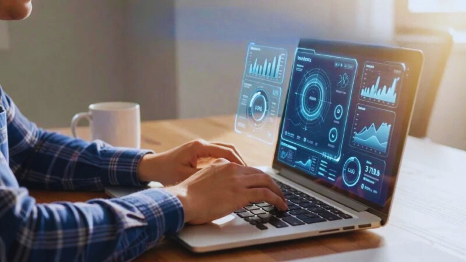 A man types on a laptop, with the screen showing various data and statistics.