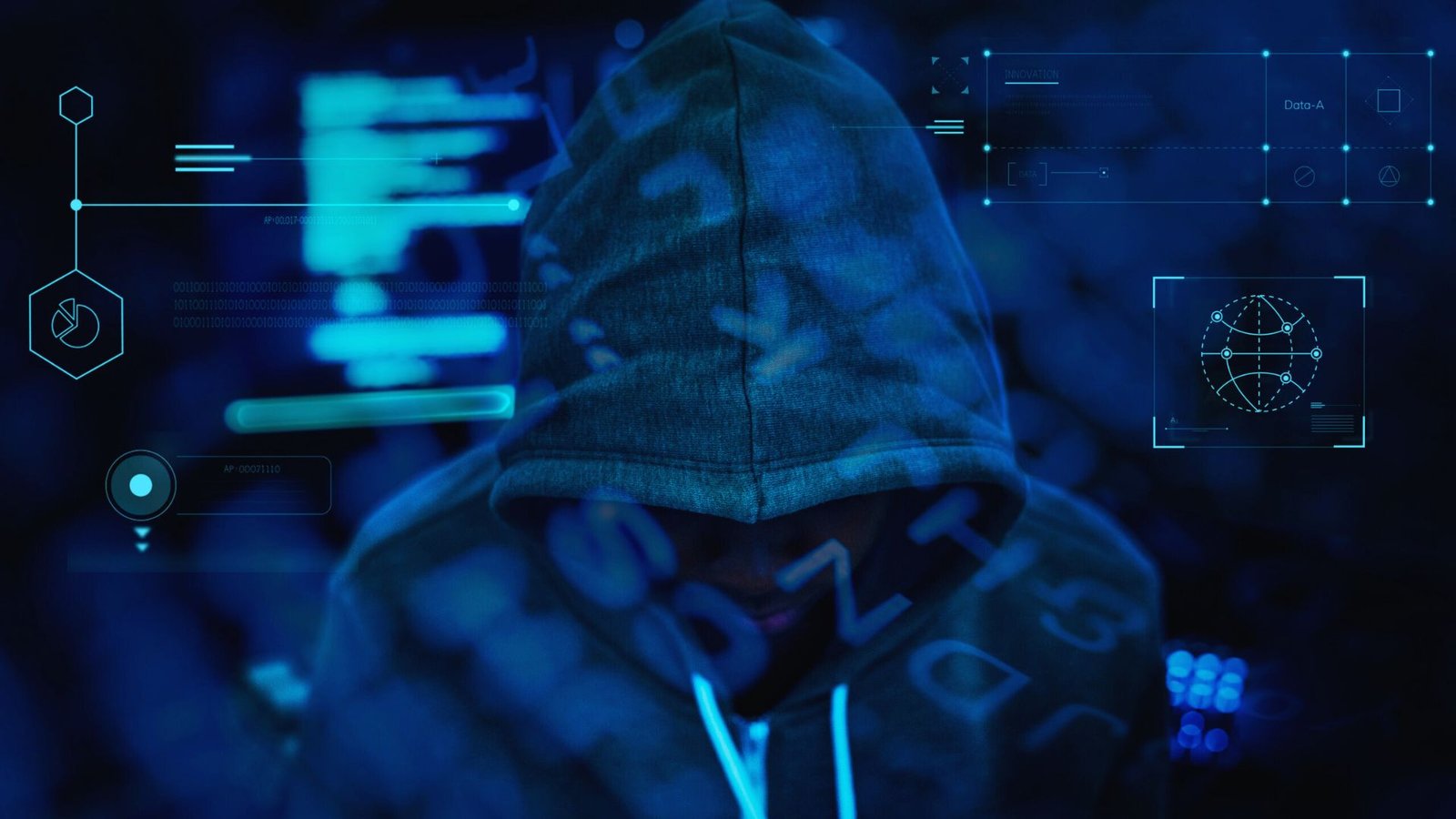 A person in a hoodie sits in front of a computer screen, focused on their work or activity.