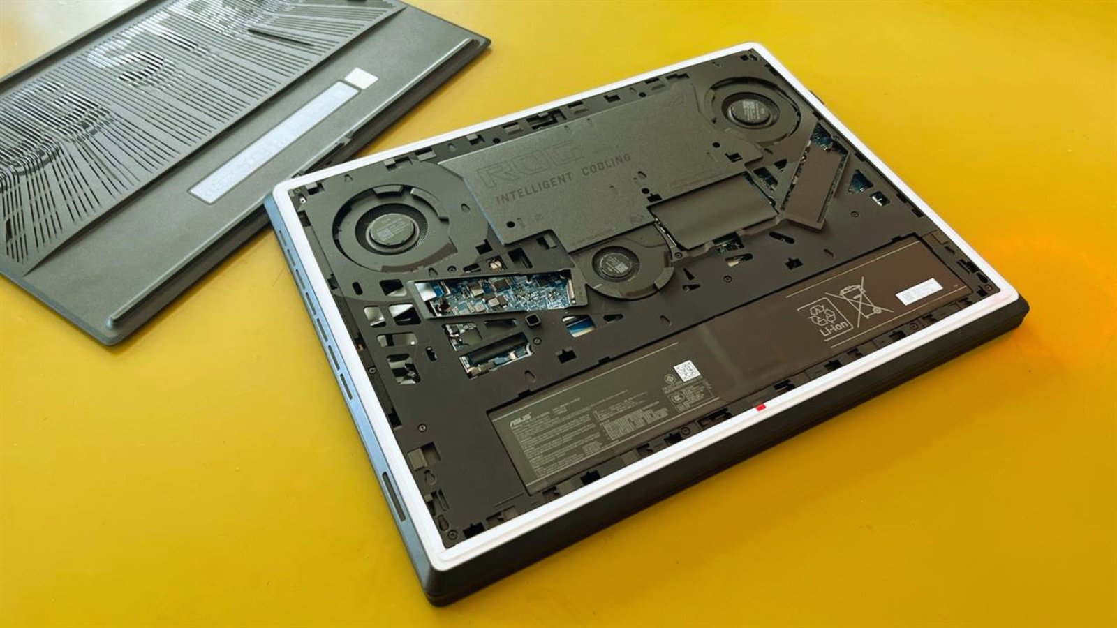  A laptop displaying an exposed motherboard alongside its keyboard, showcasing internal components and design.

