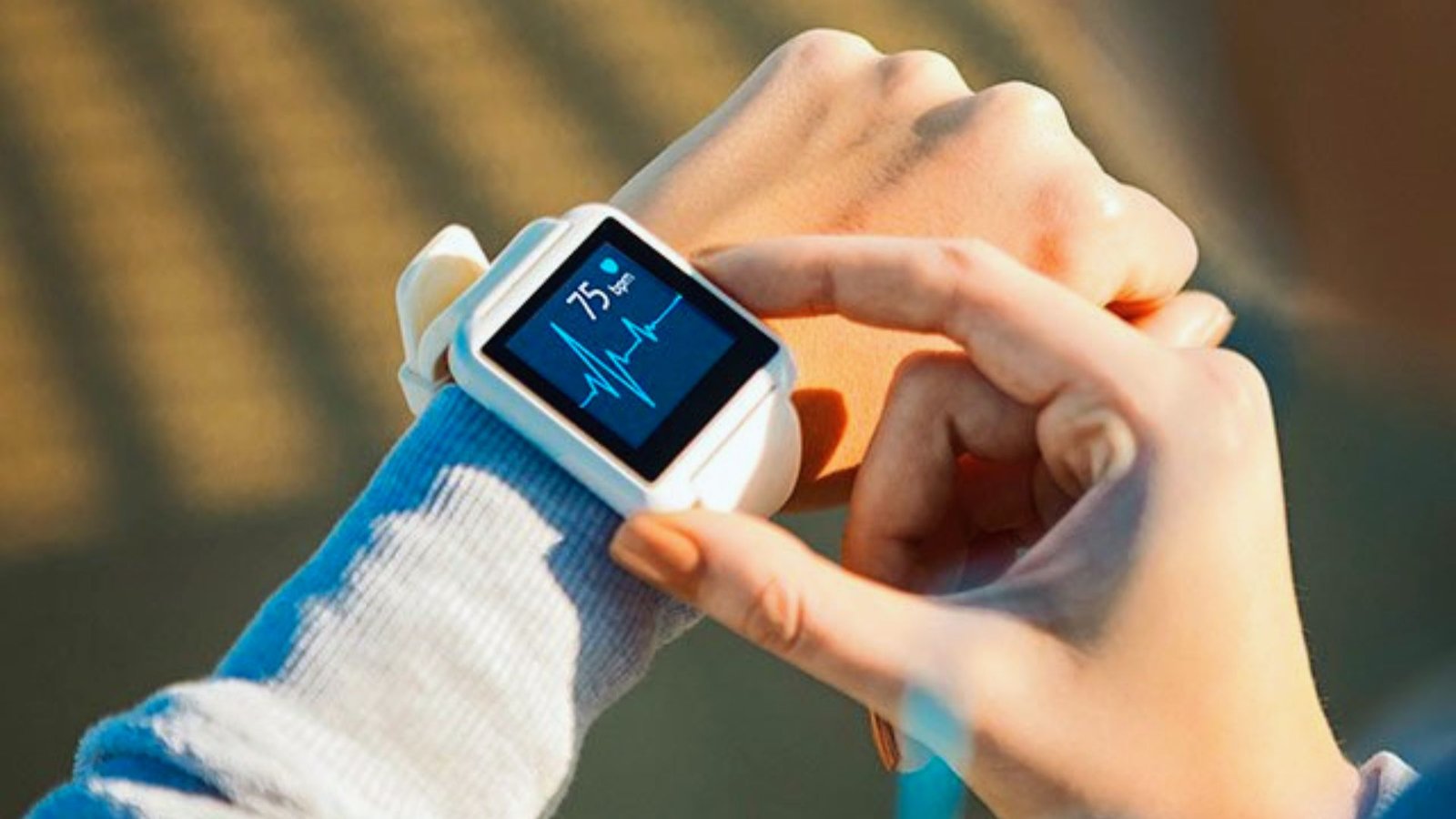 A user monitors their heart rate using a smart watch on their wrist in a casual setting.