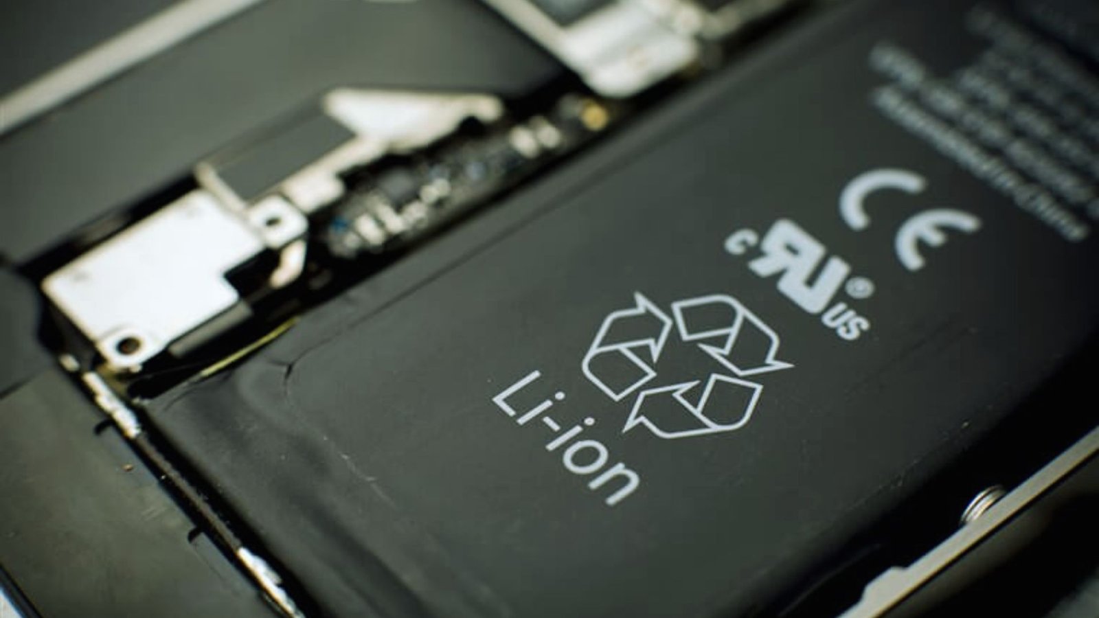  iPhone battery replacement process, showing tools and a new battery ready for installation.